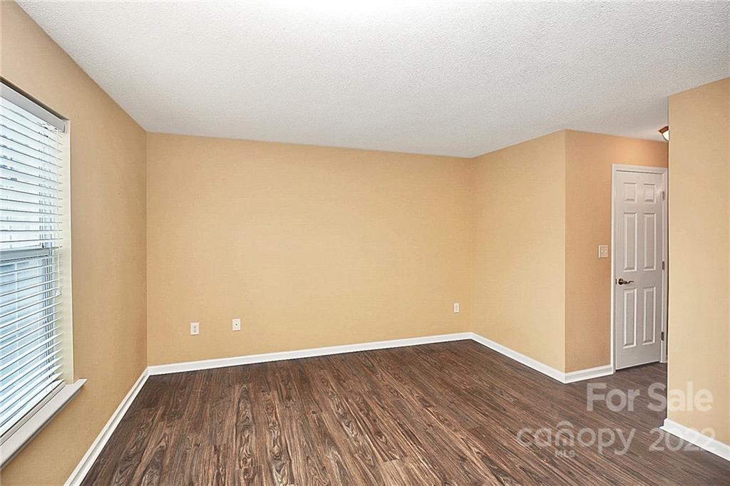 5003 Sharon Road, Unit N Charlotte, NC 28210 - Photo 6 of 11 a view of an empty room with wooden floor and a window