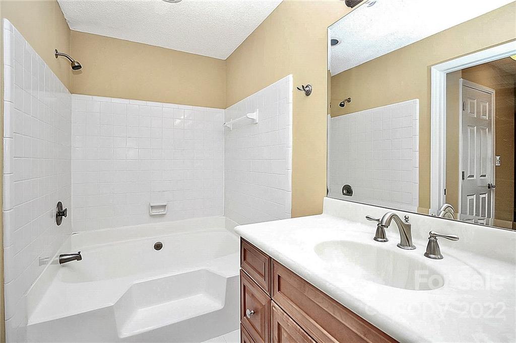 5003 Sharon Road, Unit N Charlotte, NC 28210 - Photo 7 of 11 a bathroom with a granite countertop sink and a mirror