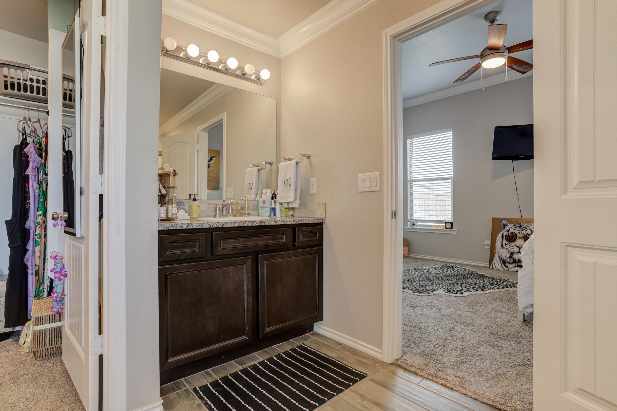 6818 40th Street Lubbock, TX 79407 - Photo 25 of 43 a bathroom with a sink and a mirror