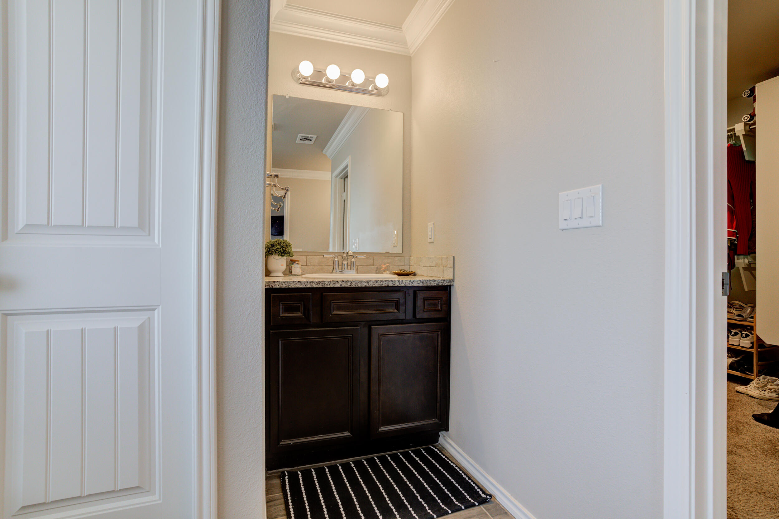 6818 40th Street Lubbock, TX 79407 - Photo 29 of 43 a bathroom with a sink and a mirror