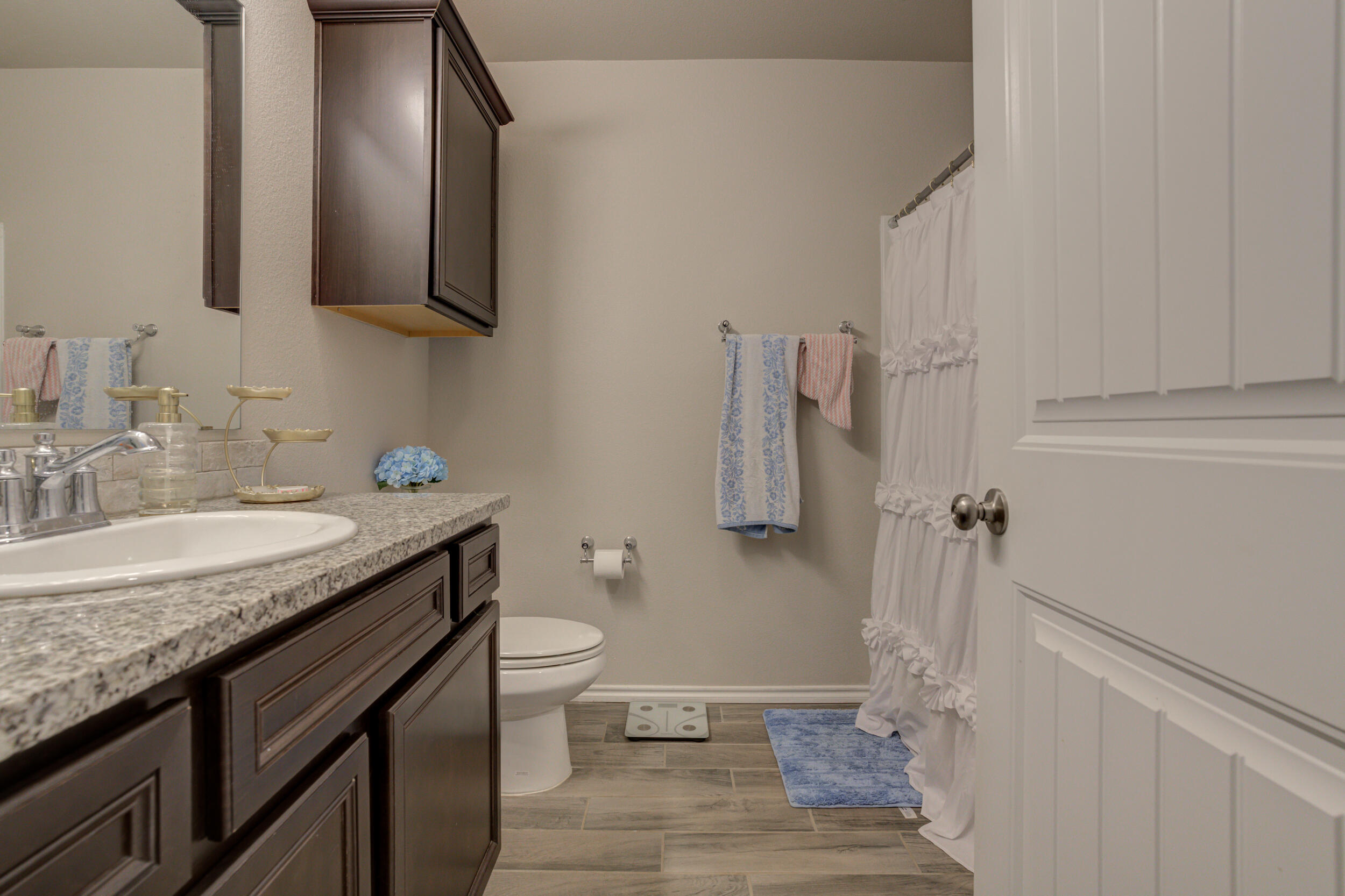 6818 40th Street Lubbock, TX 79407 - Photo 35 of 43 a bathroom with a granite countertop sink toilet and shower