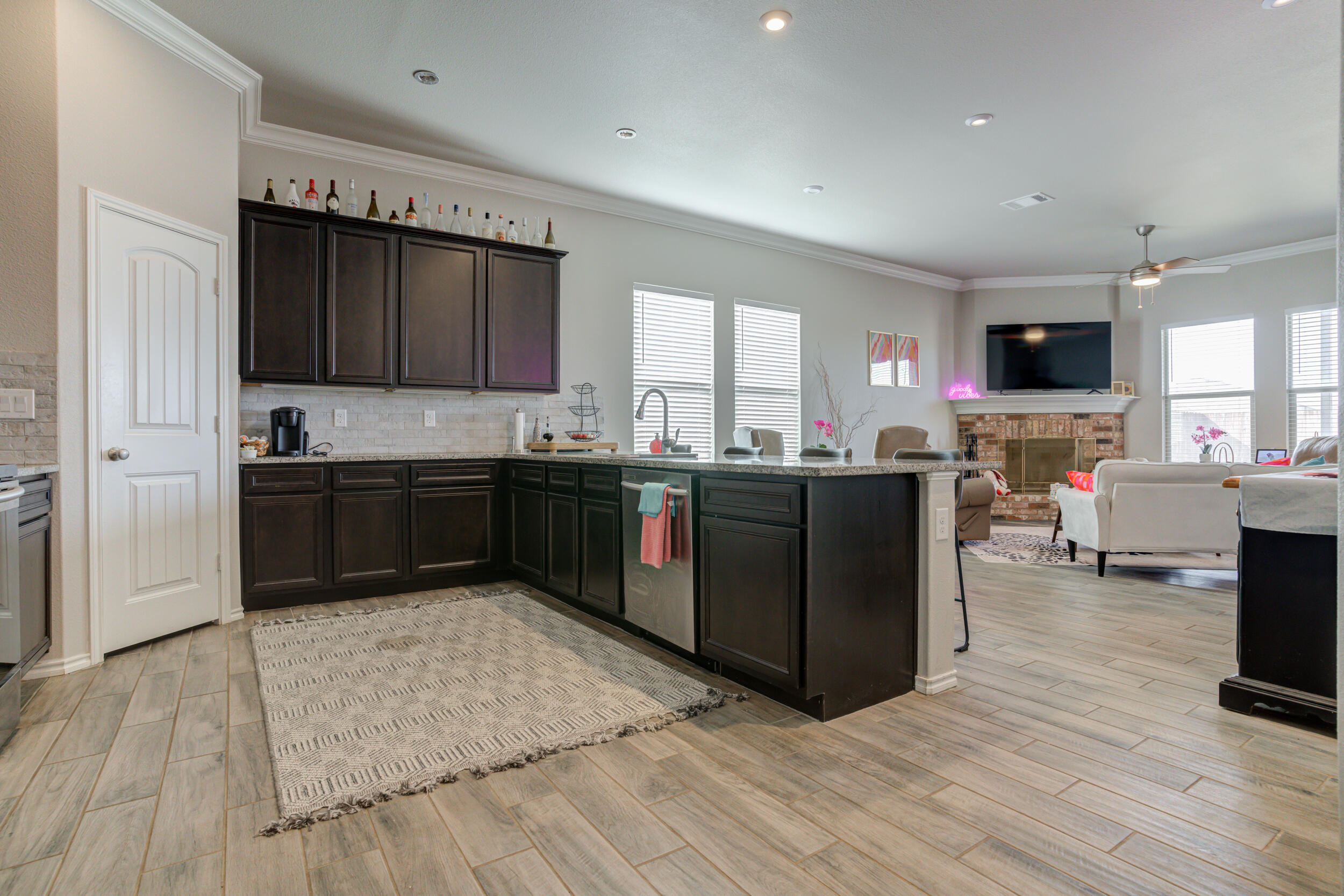 6818 40th Street Lubbock, TX 79407 - Photo 4 of 43 a kitchen with stainless steel appliances granite countertop a stove a sink dishwasher and a microwave oven with wooden floor
