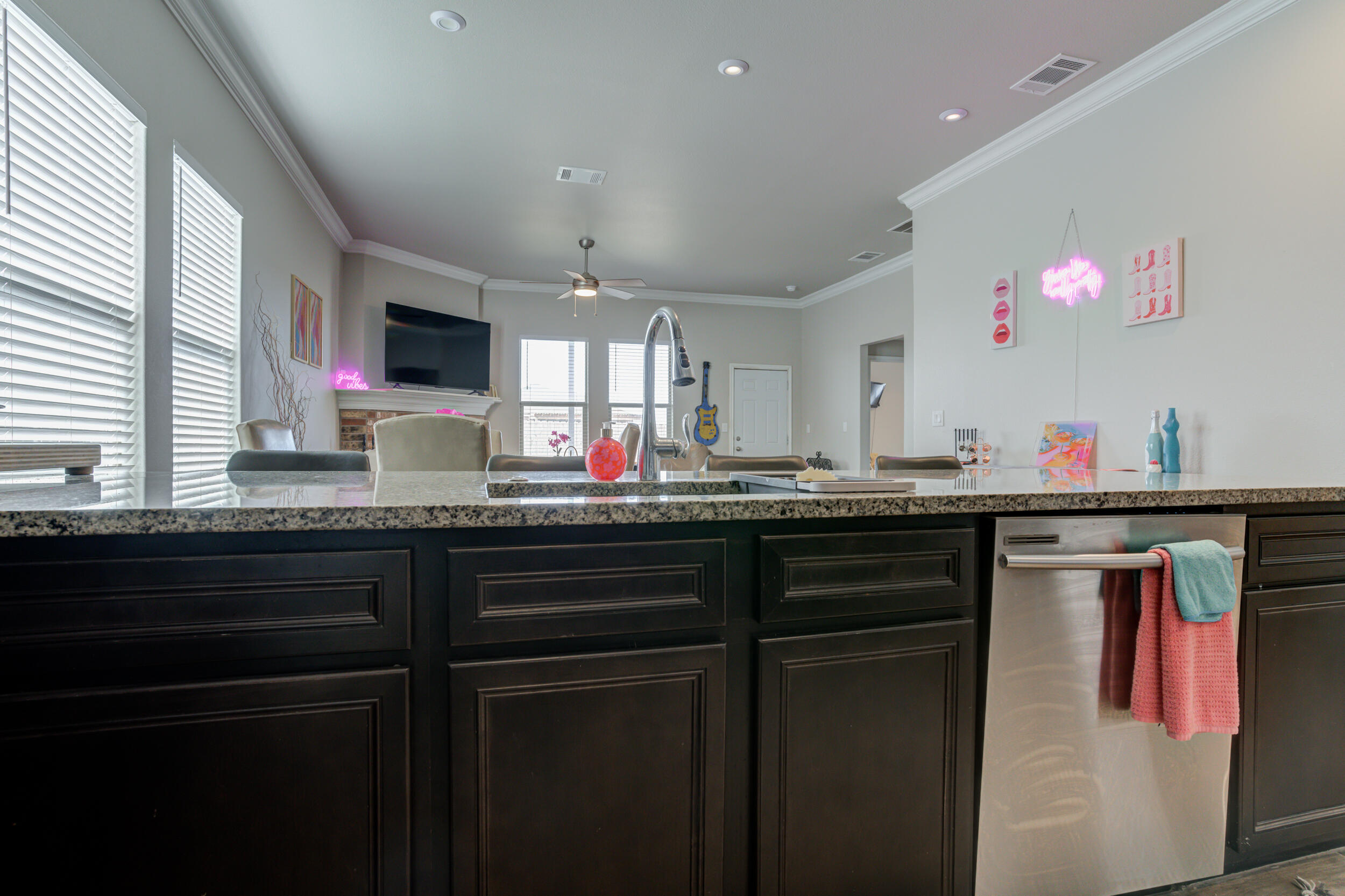 6818 40th Street Lubbock, TX 79407 - Photo 8 of 43 a kitchen with granite countertop a sink and a wooden cabinets