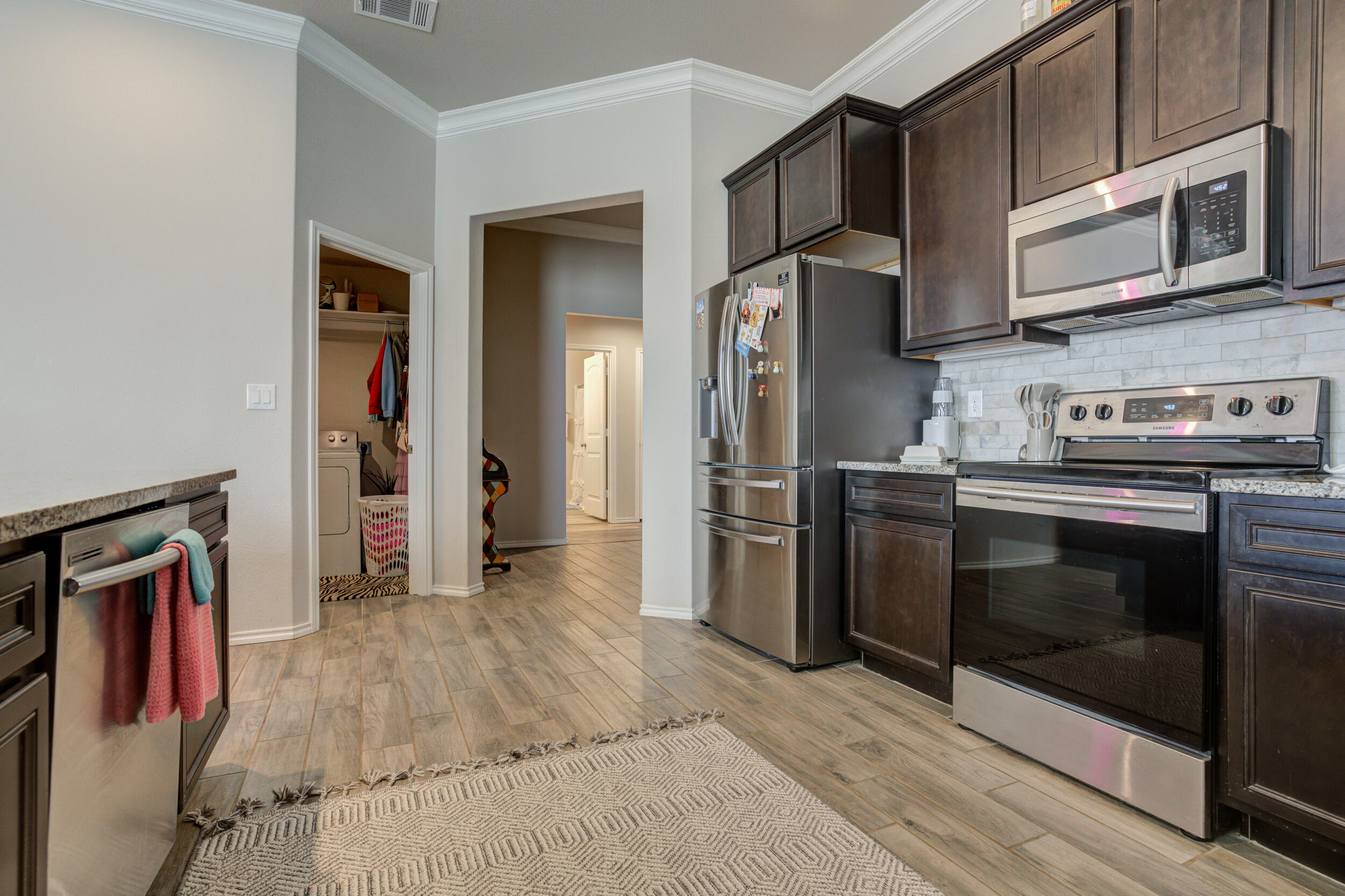 6818 40th Street Lubbock, TX 79407 - Photo 10 of 43 a kitchen with stainless steel appliances granite countertop a refrigerator microwave and stove