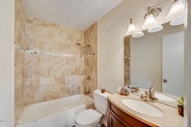 a bathroom with a sink a toilet a mirror a bathtub and shower