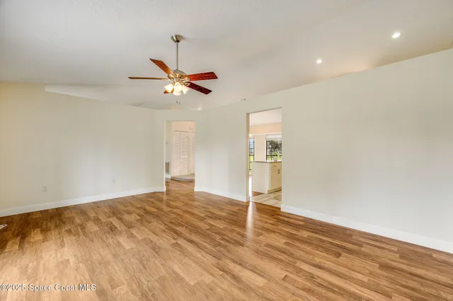 a view of a room with a ceiling fan and a ceiling fan