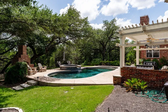 a view of a patio with table and chairs potted plants and large tree