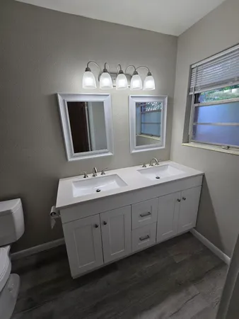 a bathroom with double vanity sink and mirror