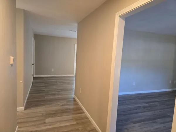 a view of a hallway with wooden floor