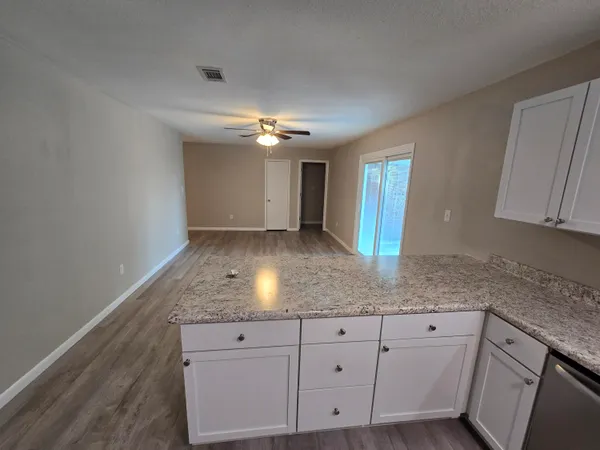 a view of a kitchen with granite countertop cabinets a sink and dishwasher