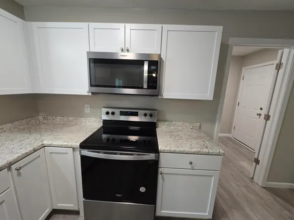 a kitchen with white cabinets and black appliances