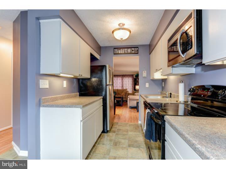 306 Paddock Drive Chesterbrook, PA 19087 - Photo 5 of 16 a kitchen with stainless steel appliances granite countertop a stove top oven a sink a dining table and chairs with wooden floor