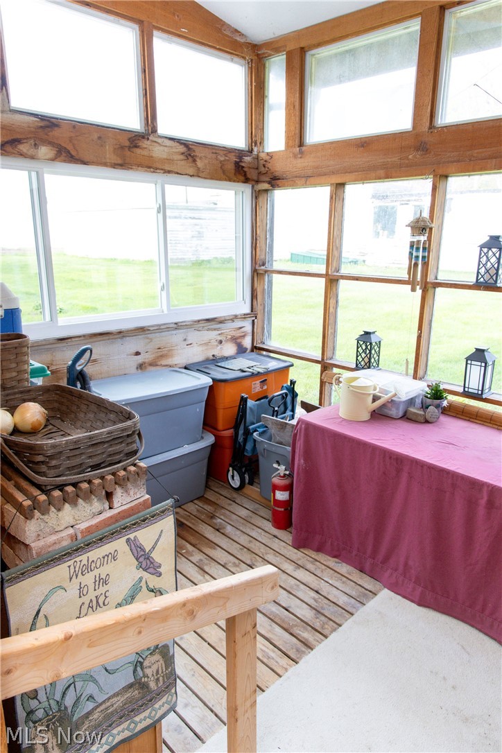 5467 Chapel Road Madison, OH 44057 - Photo 22 of 50 Sunroom with extensive window framing, wood-finish flooring, and natural wood beams