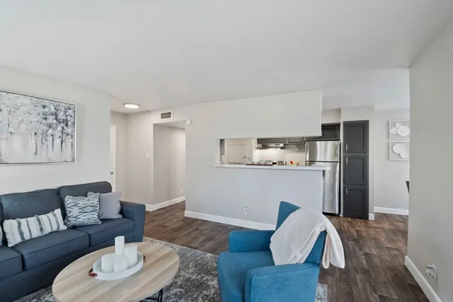 a living room with furniture and a wooden floor
