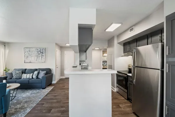 a kitchen with stainless steel appliances granite countertop a refrigerator a sink a stove and a refrigerator