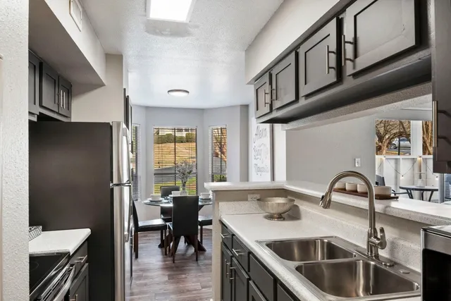 a kitchen with stainless steel appliances a sink a stove and a refrigerator