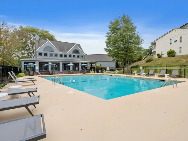 a view of house with swimming pool and yard