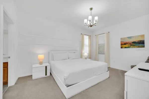 a bedroom with a bed and a chandelier