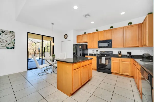 a kitchen with stainless steel appliances granite countertop a stove top oven a sink dishwasher and a refrigerator