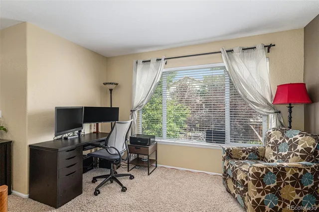 a livingroom with workspace and a window