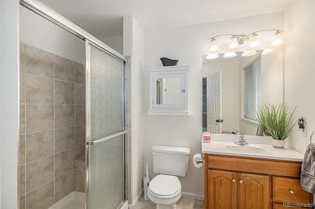 a bathroom with a granite countertop sink a toilet and shower