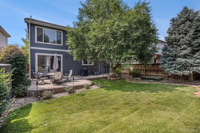 a view of a house with backyard and sitting area