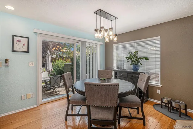 a view of a dining room with furniture a chandelier and wooden floor