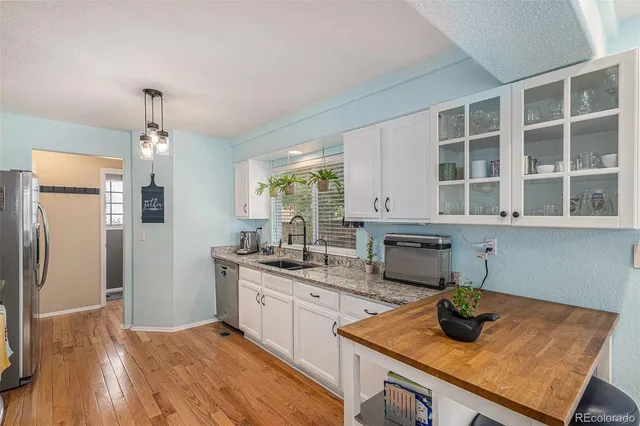 a kitchen with stainless steel appliances granite countertop a sink refrigerator and cabinets