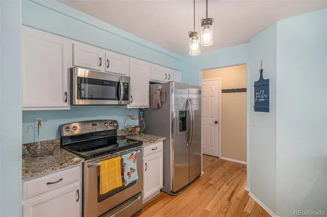 a kitchen with stainless steel appliances granite countertop a refrigerator a stove top oven a sink and dishwasher