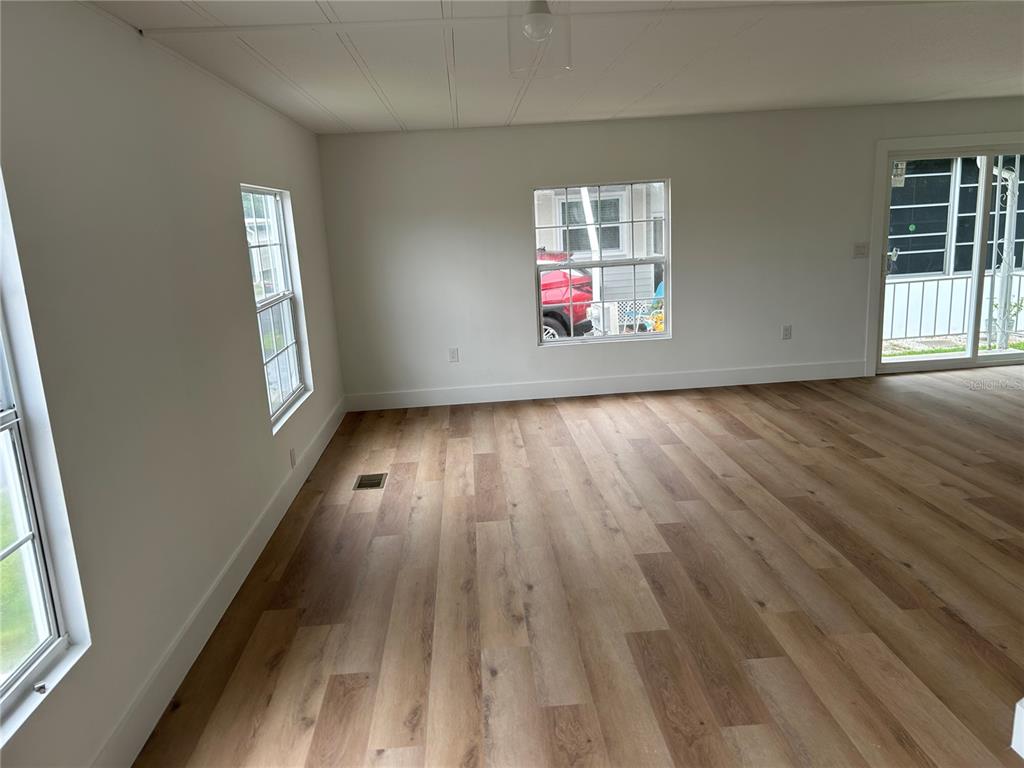 4443 Tucker Square New Port Richey, FL 34652 - Photo 14 of 24 an empty room with wooden floor and windows