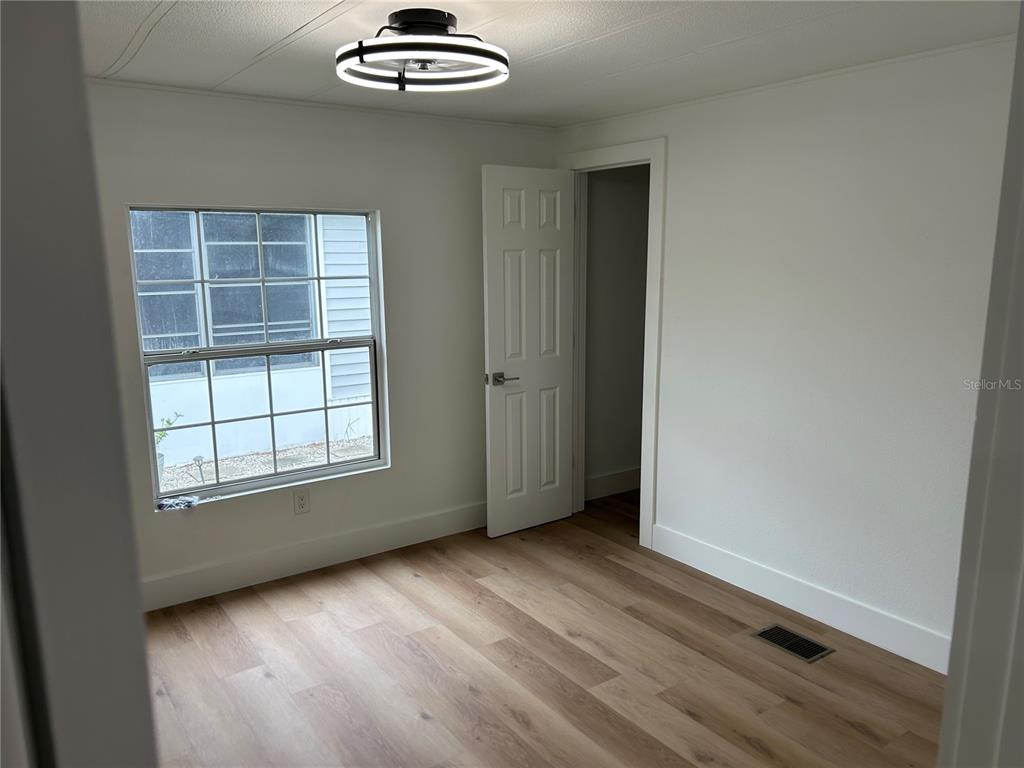 4443 Tucker Square New Port Richey, FL 34652 - Photo 17 of 24 an empty room with chandelier fan and windows