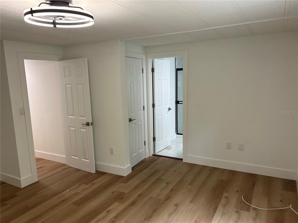 4443 Tucker Square New Port Richey, FL 34652 - Photo 21 of 24 an empty room with wooden floor and chandelier