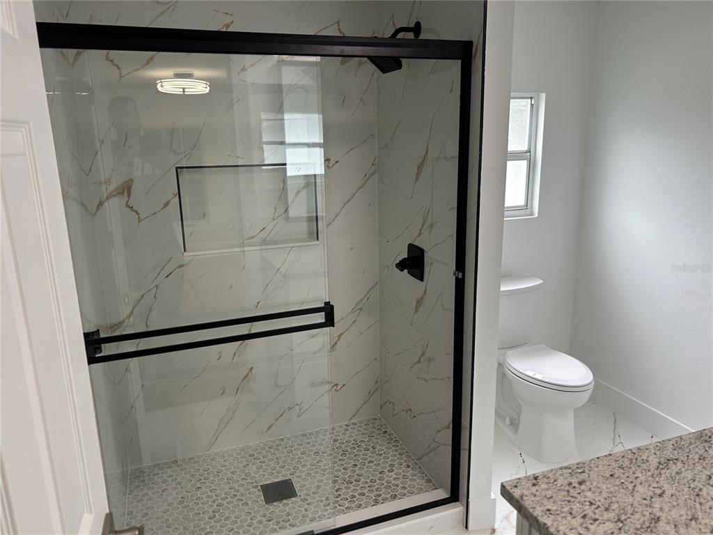 4443 Tucker Square New Port Richey, FL 34652 - Photo 23 of 24 a bathroom with a shower and toilet