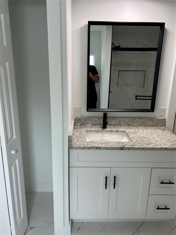 4443 Tucker Square New Port Richey, FL 34652 - Photo 24 of 24 a bathroom with a granite countertop sink and a mirror