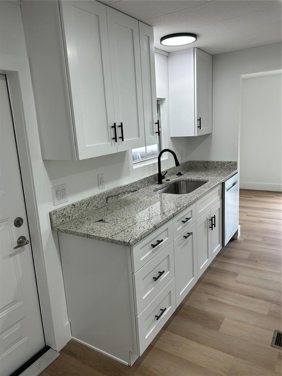4443 Tucker Square New Port Richey, FL 34652 - Photo 10 of 24 a bathroom with a granite countertop sink and a mirror