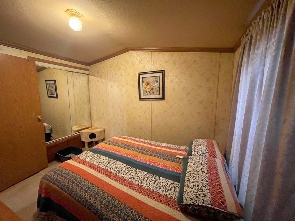 11 Groton School Road, Unit 8 Ayer, MA 01432 - Photo 13 of 14 a bedroom with a bed and wooden floor
