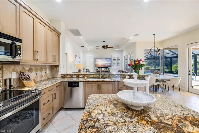 a large kitchen with kitchen island stainless steel appliances a stove a sink and a dining table