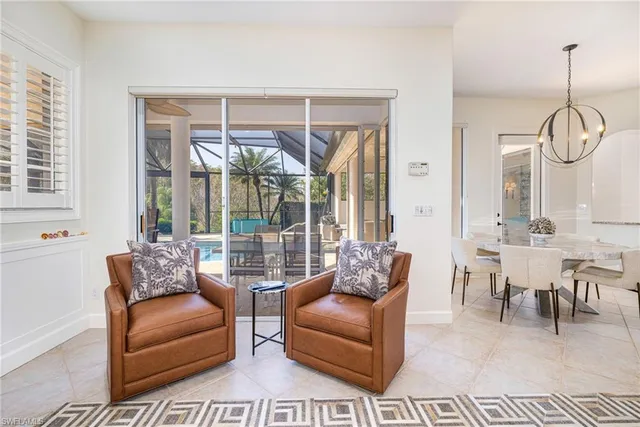 a living room with furniture a large window and a chandelier