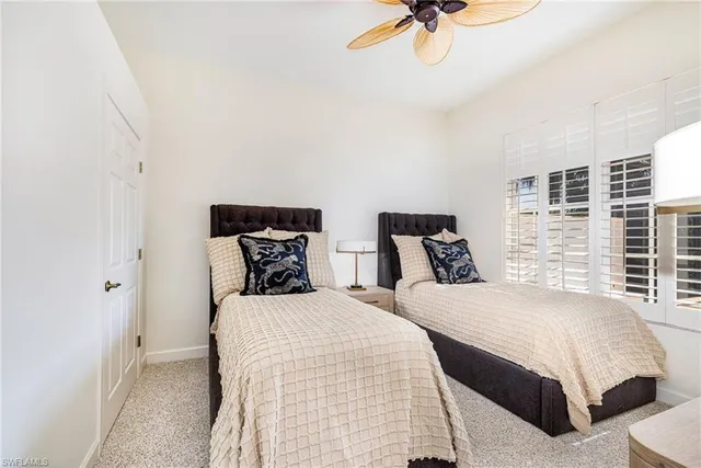 a bedroom with two beds and a chandelier