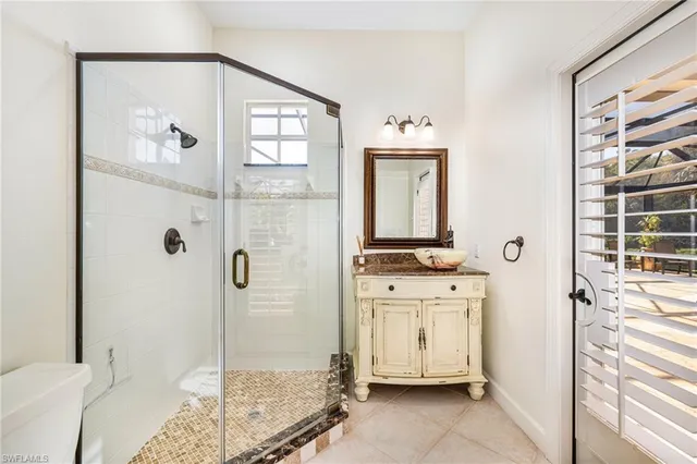 a bathroom with a granite countertop sink a mirror and a shower