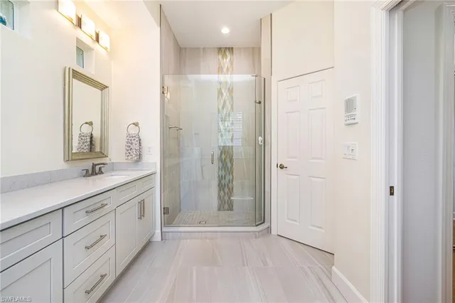 a bathroom with a glass shower door and a sink