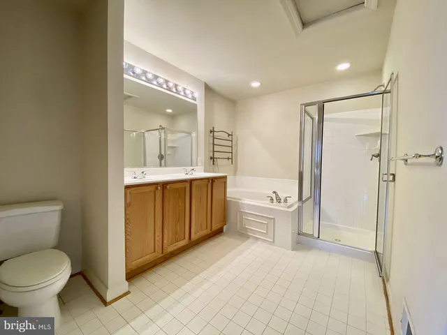 a bathroom with a granite countertop toilet a sink and a mirror
