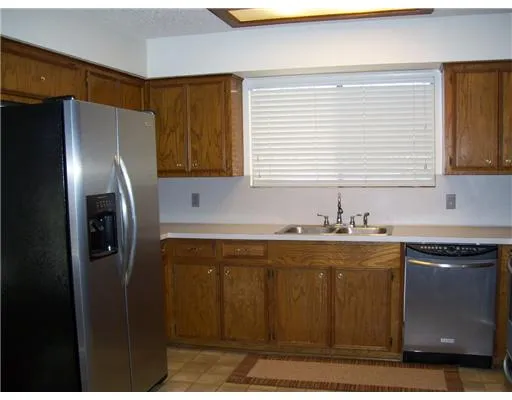 a kitchen with stainless steel appliances granite countertop a sink a refrigerator and a granite counter tops