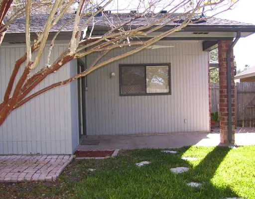 a view of backyard with barbeque grill and wooden fence