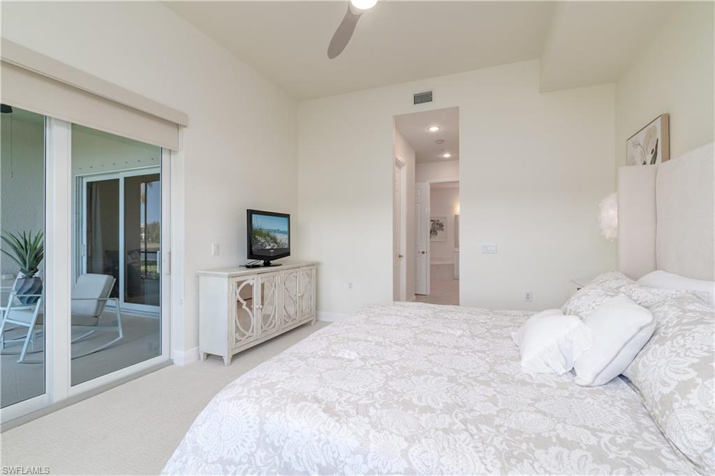 9271 Museo Circle, Unit 102 Naples, FL 34114 - Photo 11 of 35 a bedroom with a white bed and a flat screen tv