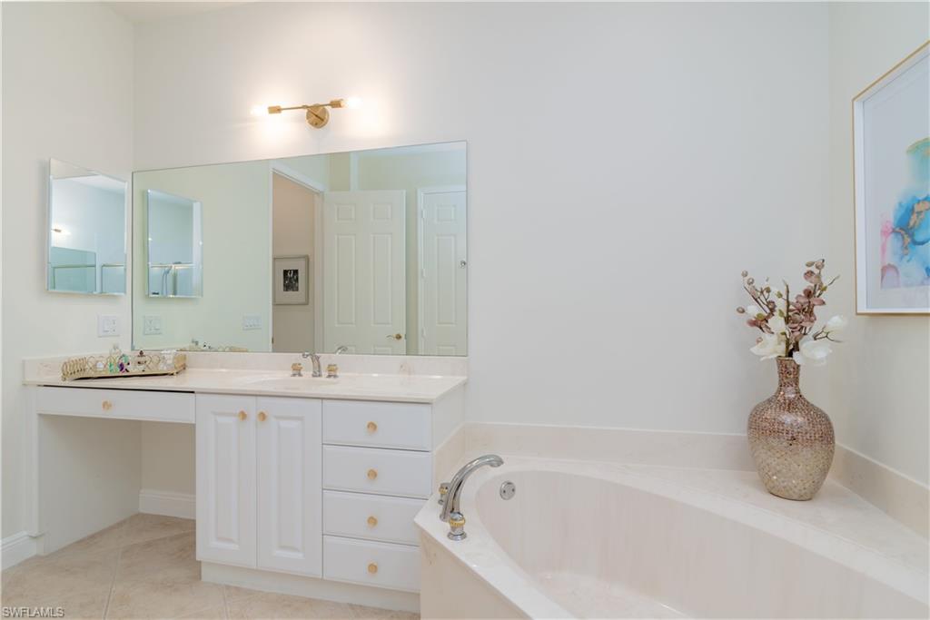 9271 Museo Circle, Unit 102 Naples, FL 34114 - Photo 13 of 35 a bathroom with a tub sink and mirror