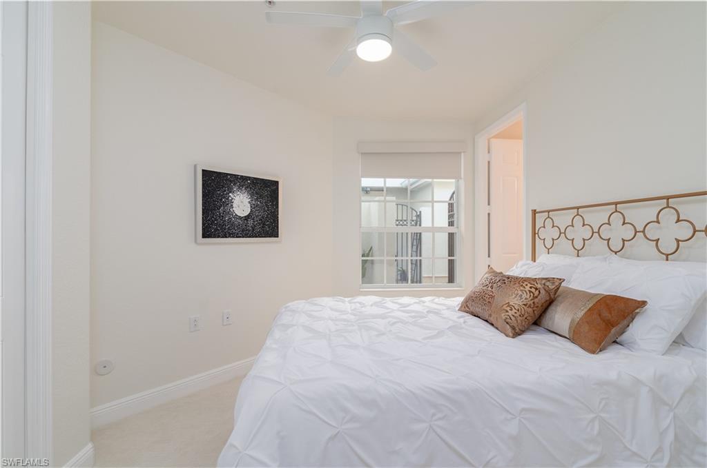 9271 Museo Circle, Unit 102 Naples, FL 34114 - Photo 14 of 35 a large bed sitting in a bedroom next to a window