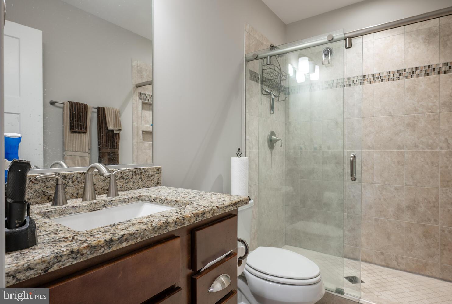 1126 North Stuart Street Arlington, VA 22201 - Photo 12 of 38 a bathroom with a granite countertop sink toilet a mirror and shower