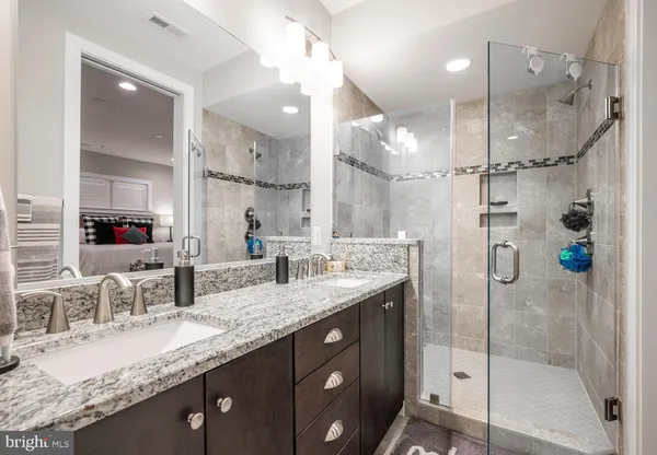 a bathroom with a granite countertop sink mirror and shower