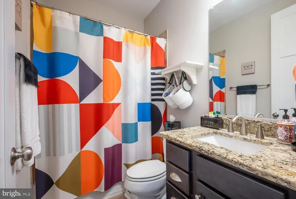 a bathroom with a sink vanity mirror and toilet